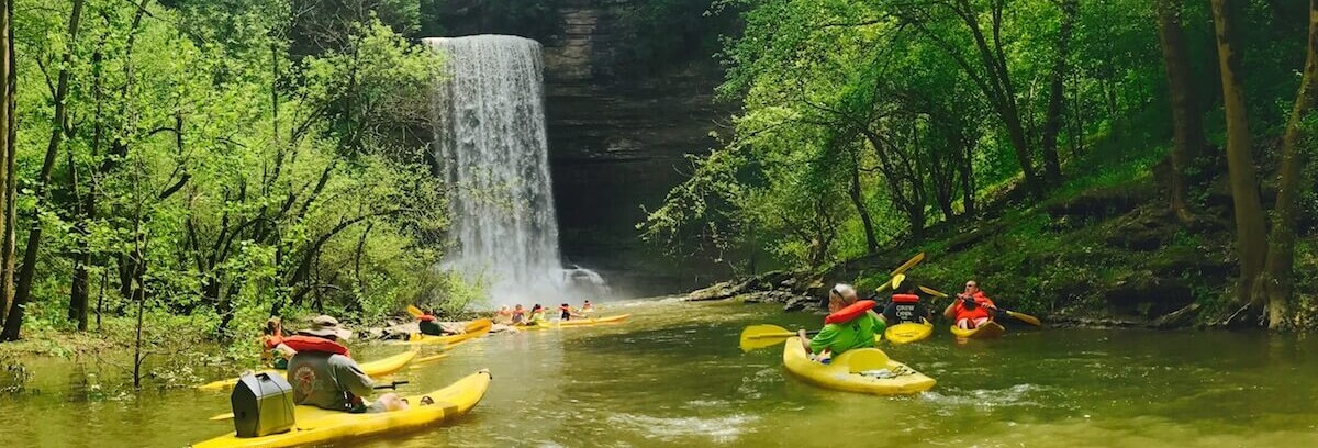 Family paddling single and tandem kayaks on the Caney Fork River near Silver Point, Tennessee